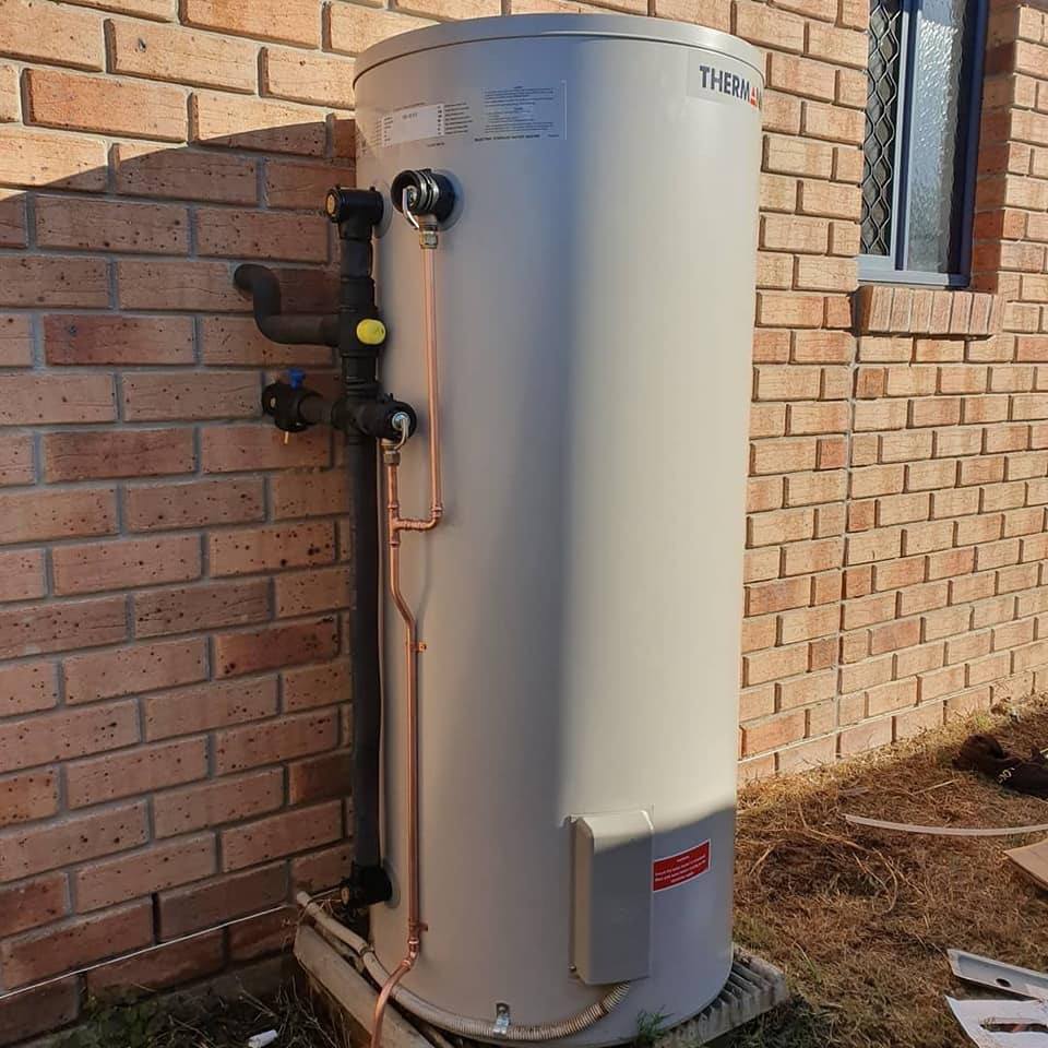 Plumber inspecting a gas-powered hot water system