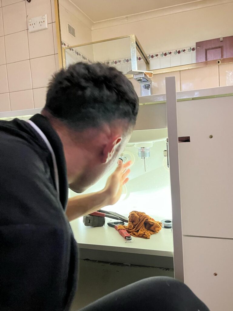 A Nowra plumber inspecting pipes for potential leaks using non-invasive detection methods.